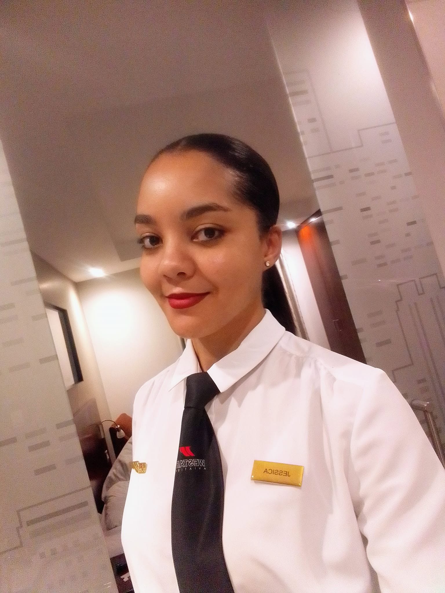 Jessica in a white aviation uniform shirt and black tie